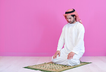 Image showing young arabian muslim man praying on the floor at home