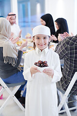 Image showing little muslim boy holding a plate full of sweet dates