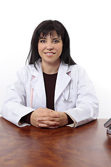 Image showing Smiling doctor sitting at desk