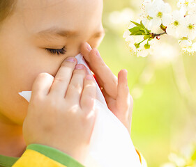 Image showing Little girl is blowing her nose