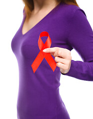 Image showing Woman is holding the red awareness ribbon