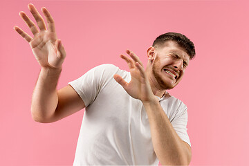 Image showing Portrait of the scared man on pink