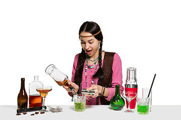 Image showing Expert female barman is making cocktail at studio