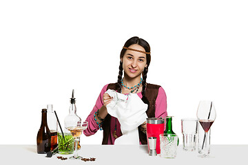 Image showing Expert female barman is making cocktail at studio