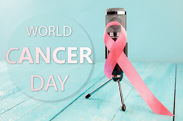 Image showing the text world cancer day and a pink ribbon on a table background