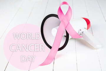 Image showing the text world cancer day and a pink ribbon on a table background