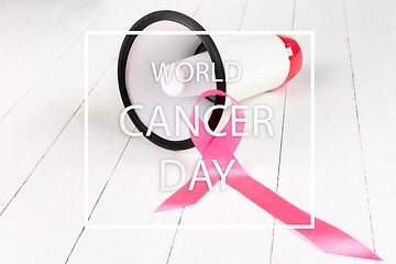 Image showing the text world cancer day and a pink ribbon on a table background