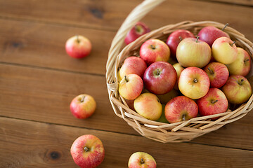 Image showing ripe apples in wicker basket on wooden table