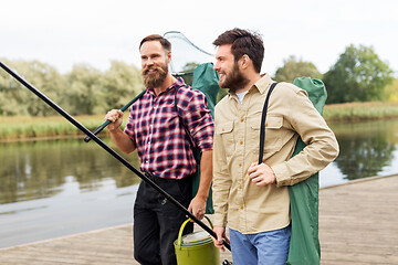 Image showing male friends with net and fishing rods on lake