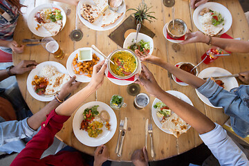 Image showing international friends eating at restaurant