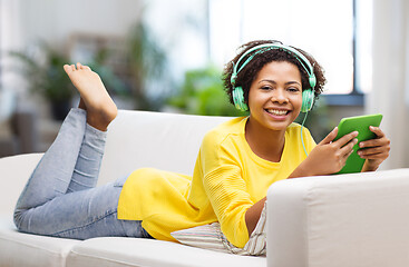 Image showing happy african woman with tablet pc and headphones