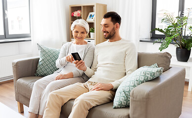 Image showing old mother and adult son with smartphone at home