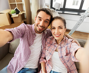 Image showing happy couple taking selfie at new home