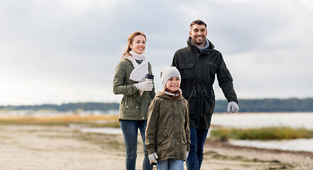 Image showing happy family walking along autumn beach