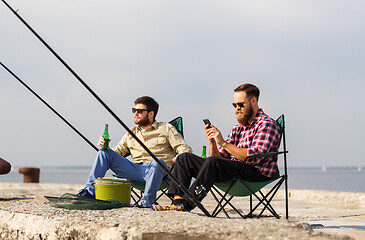 Image showing friends with smartphone fishing and drinking beer