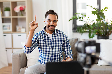 Image showing male blogger with camera videoblogging at home