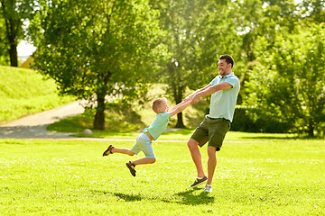 Image showing happy father and son having fun at summer park