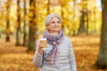 Image showing senior woman drinking coffee in autumn park