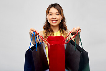 Image showing happy asian woman with open shopping bags