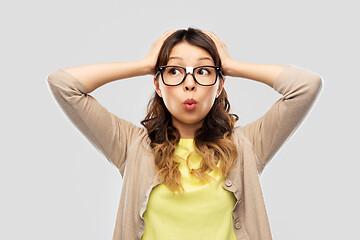 Image showing asian female student in glasses holding to head