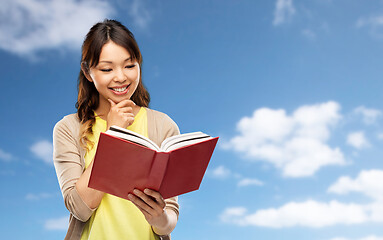 Image showing happy asian woman reading book