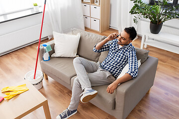 Image showing man calling on smartphone after cleaning home