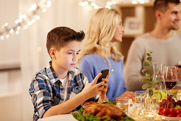 Image showing boy with smartphone at family dinner party