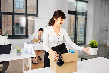 Image showing happy businesswoman with personal stuff at office