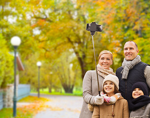 Image showing happy family with smartphone and monopod in park