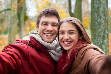 Image showing happy young couple taking selfie in autumn park