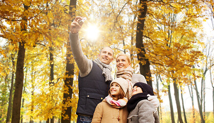 Image showing happy family with camera in autumn park