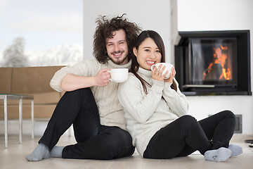 Image showing happy multiethnic couple  in front of fireplace