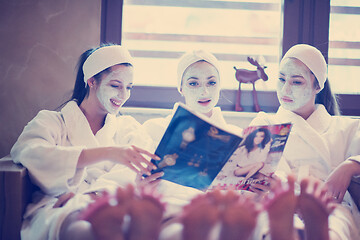 Image showing bachelorette party in spa, girls with face mask reading magazine