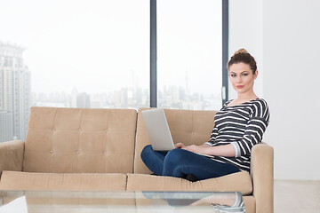 Image showing young woman on sofa at home websurfing