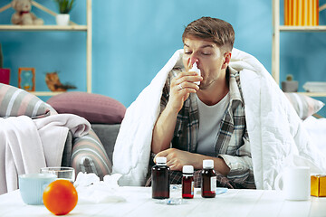 Image showing Bearded sick man with flue sitting on sofa at home. Illness, influenza, pain concept. Relaxation at Home. Healthcare Concepts.