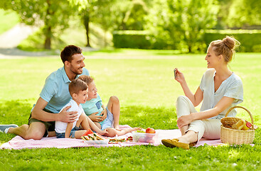 Image showing mother taking picture of family on picnic at park