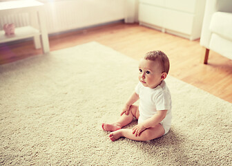 Image showing happy baby boy or girl sitting on floor at home