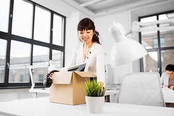 Image showing happy businesswoman with personal stuff at office