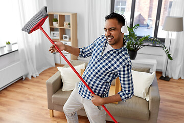 Image showing man with broom cleaning and having fun at home