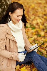 Image showing woman with tablet computer at autumn park