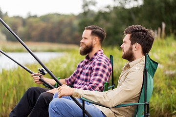 Image showing male friends with fishing rods on lake