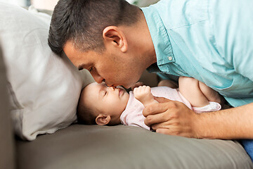 Image showing middle aged father kissing baby daughter at home