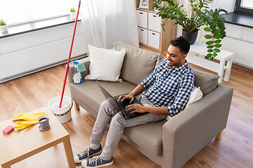 Image showing man with laptop computer after home cleaning