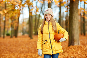 Image showing happy girl with pumpkin at autumn park