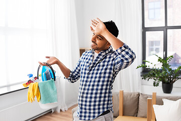 Image showing tired man with bucket of cleaning stuff at home