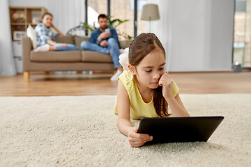 Image showing girl with tablet computer lying on floor at home
