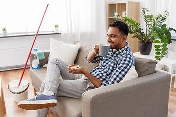 Image showing man drinking coffee, resting after home cleaning