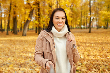 Image showing woman taking picture by selfiestick at autumn park