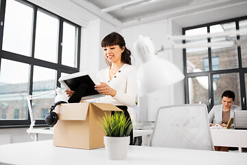 Image showing happy businesswoman with personal stuff at office