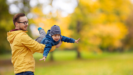 Image showing father with son playing and having fun in autumn